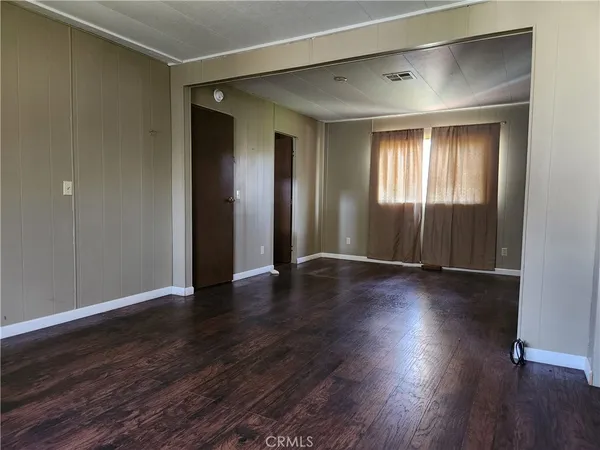 an empty room with wooden floor and entrance