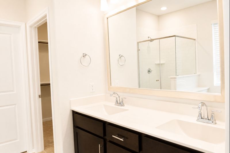 693 Durian Loop Buda, TX 78610 - Photo 16 of 27 Double vanity with ample counter space and sleek dark cabinetry offers a functional and organized start to your day.