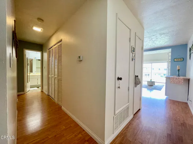 a view of a hallway with wooden floor and a living room