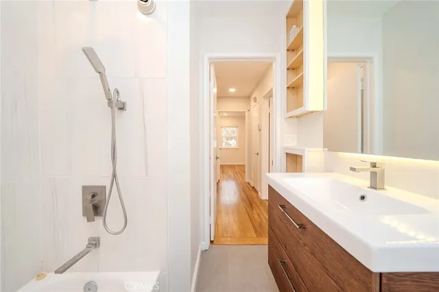 a bathroom with a granite countertop shower a sink and a mirror