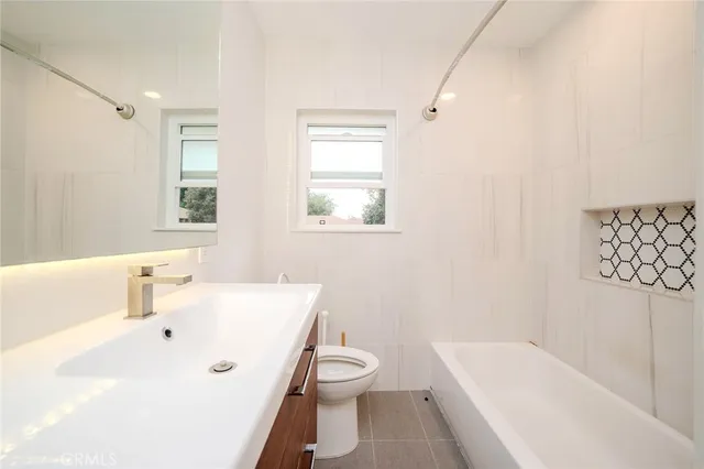 a bathroom with a tub a sink and a window