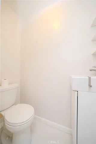a white toilet sitting next to a white sink