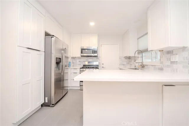 a kitchen with refrigerator and cabinets