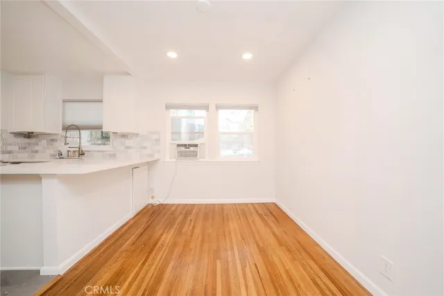 a hallway with a sink and wooden floor