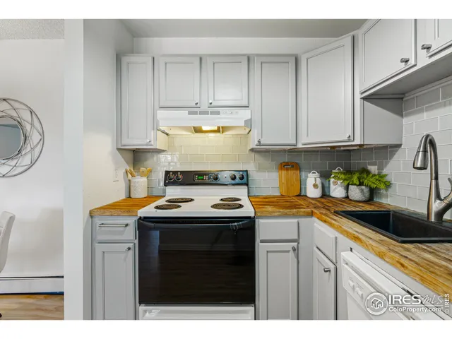 a kitchen with kitchen island granite countertop a sink a stove and cabinets