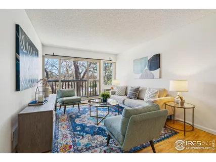 a living room with furniture and a floor to ceiling window