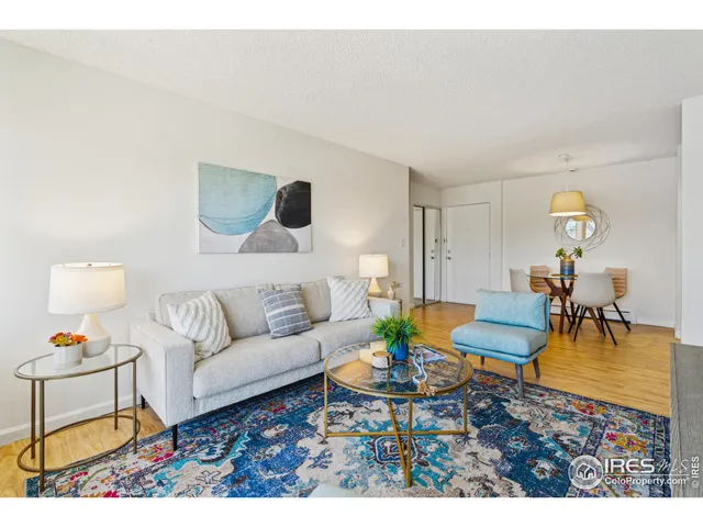 a living room with furniture a rug and a table