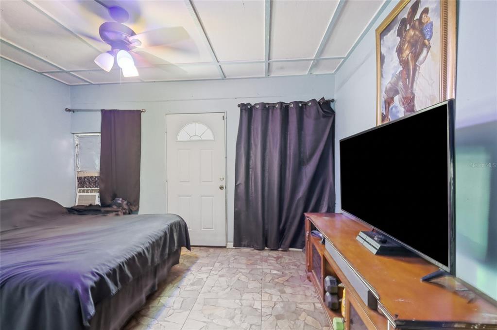 3027 Queens Gate Road Orlando, FL 32818 - Photo 33 of 34 a bedroom with a bed and a flat tv screen on dresser