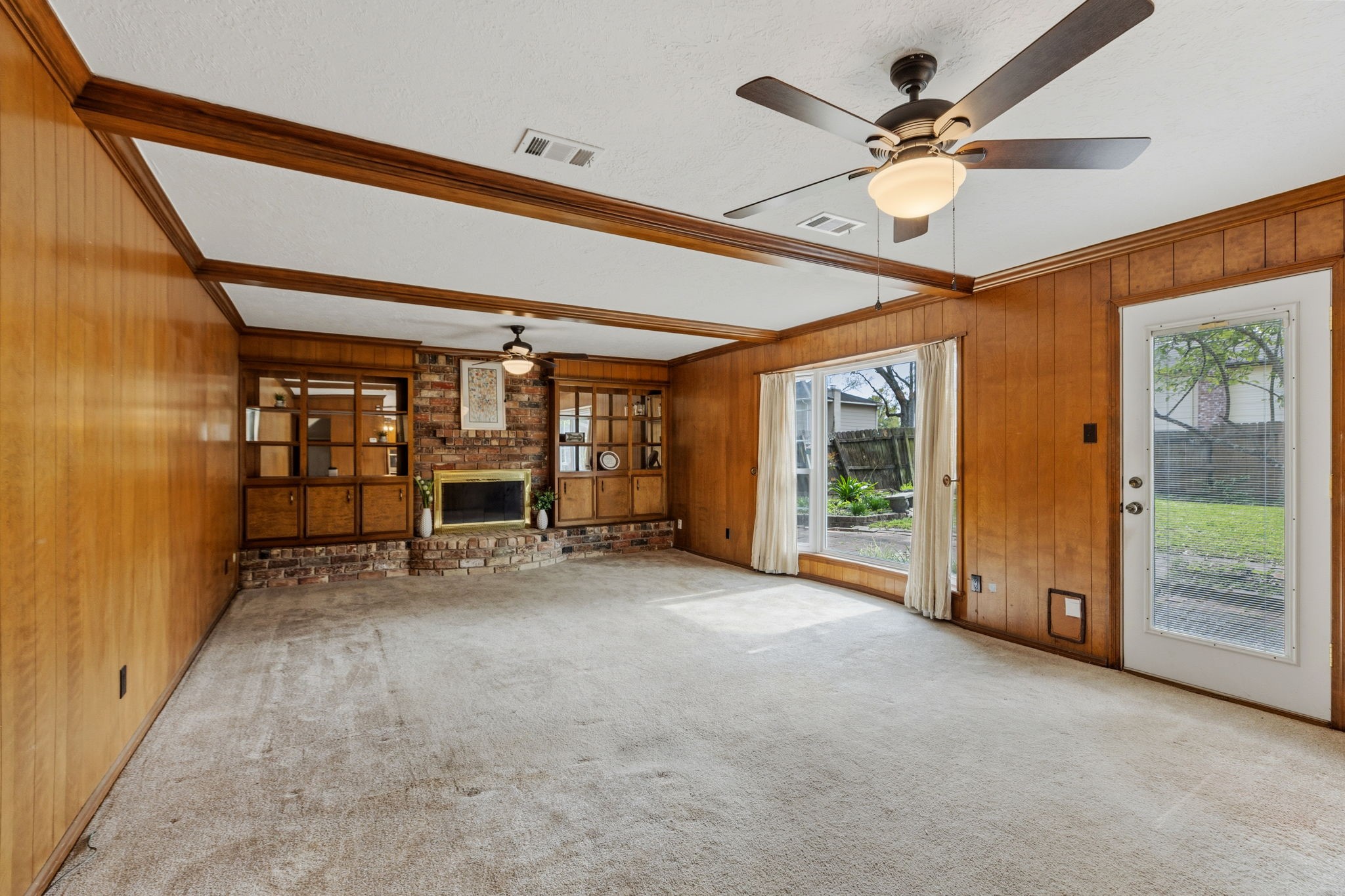 17507 Oxhill Court Spring, TX 77388 - Photo 8 of 44 The cozy family room has warm, wood paneling on the walls, beautiful beams across the ceiling, and built in shelves surrounding the fireplace.