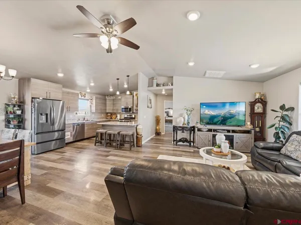 a living room with furniture kitchen view and a flat screen tv