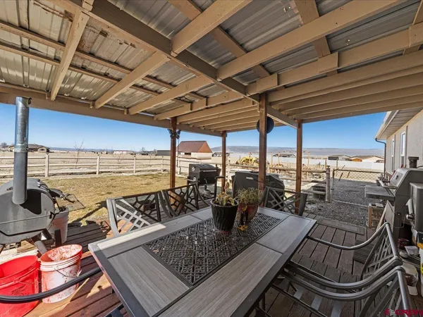 a view of a patio with lawn chairs floor to ceiling window and outdoor kitchen