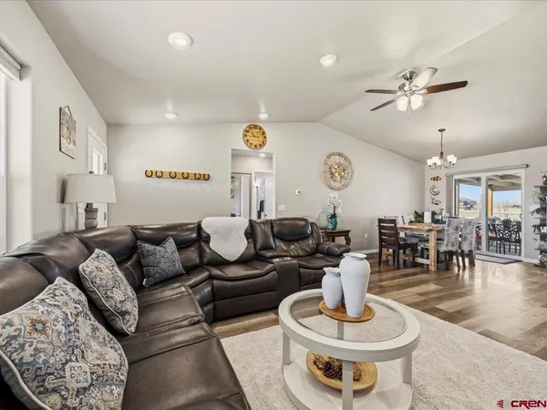 a living room with furniture kitchen view and a chandelier