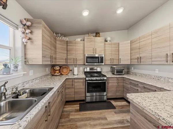 a kitchen with stainless steel appliances kitchen island granite countertop a sink stove and cabinets