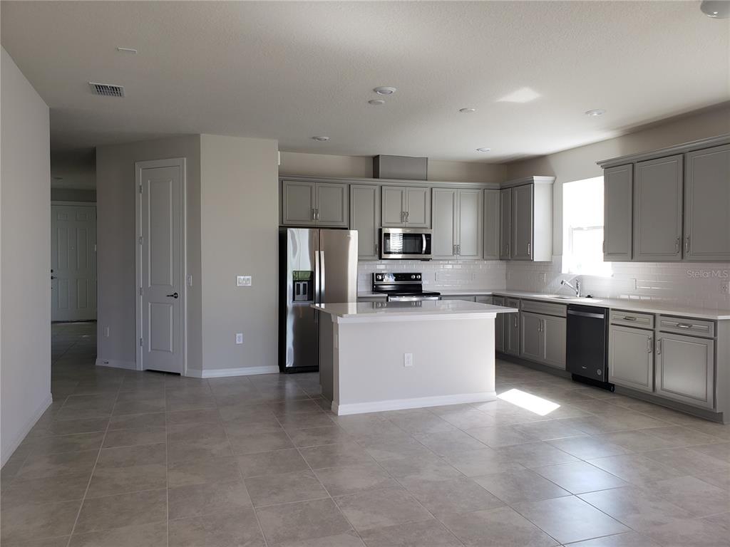 17244 Cagan Crossings Boulevard Clermont, FL 34714 - Photo 3 of 14 a kitchen with refrigerator cabinets and microwave