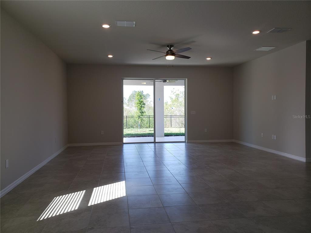 17244 Cagan Crossings Boulevard Clermont, FL 34714 - Photo 4 of 14 an empty room with wooden floor and windows