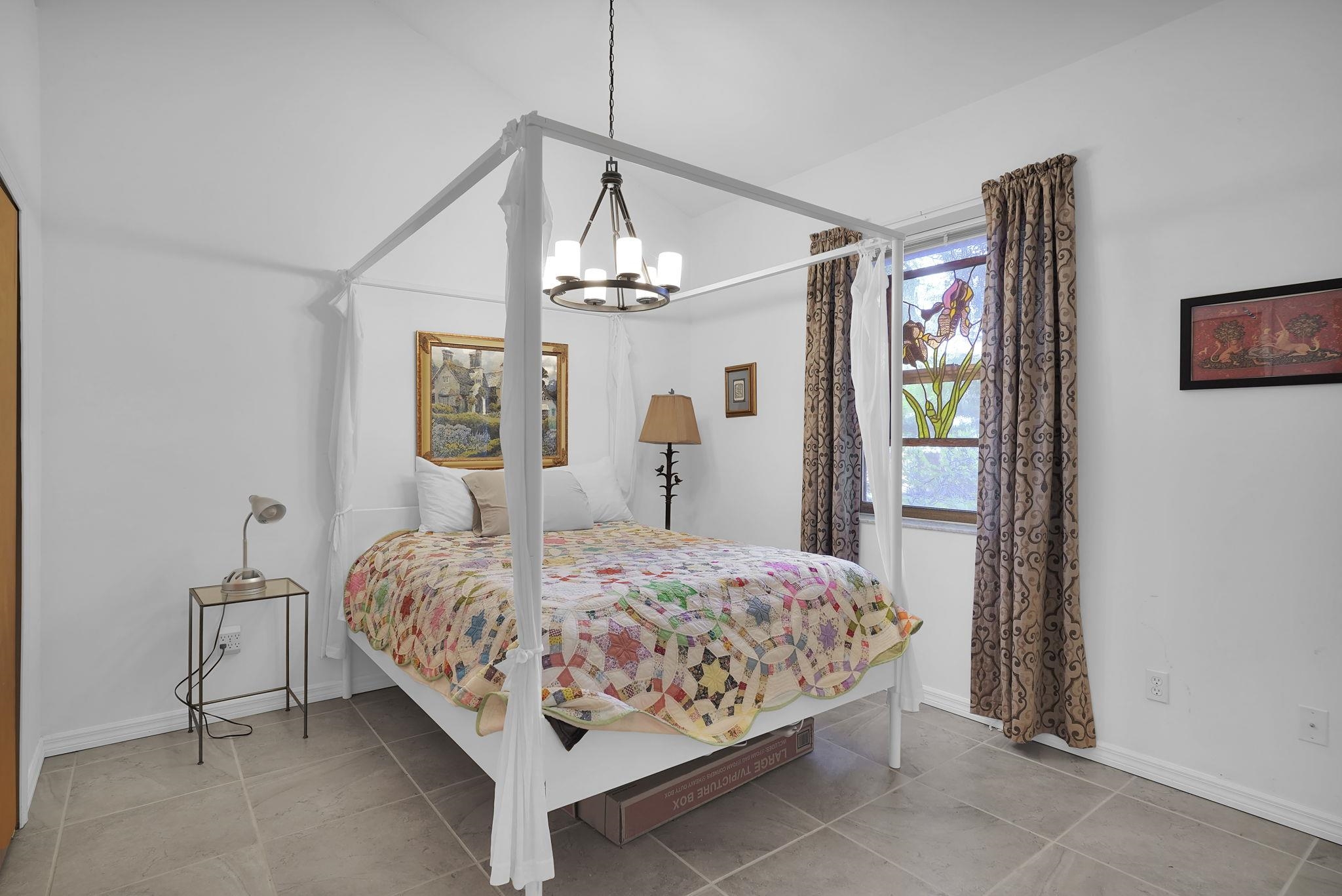 3372 Kings Road South St. Augustine, FL 32086 - Photo 16 of 48 a bedroom with a bed chandelier and painting on the wall