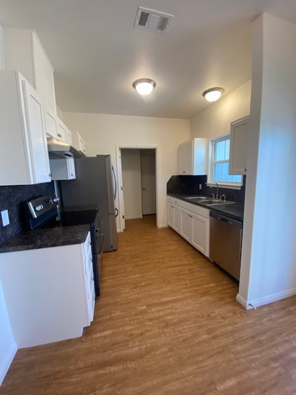 112 Palmo Drive Luling, TX 78648 - Photo 19 of 24 a kitchen with stainless steel appliances granite countertop a stove and a refrigerator