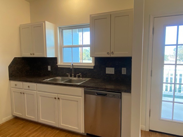 112 Palmo Drive Luling, TX 78648 - Photo 23 of 24 a kitchen with granite countertop white cabinets and sink