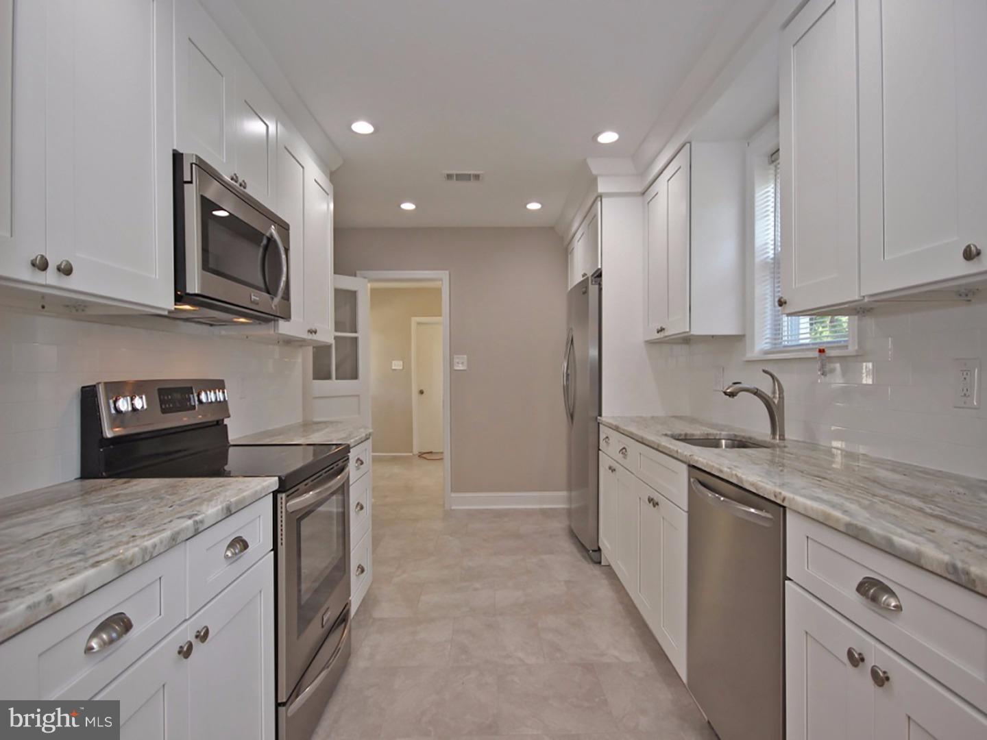 449 Pinecrest Road Springfield, PA 19064 - Photo 7 of 25 a kitchen with stainless steel appliances granite countertop a sink a stove and a refrigerator