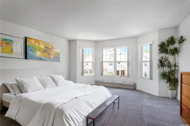 a spacious bedroom with a large bed and a potted plant