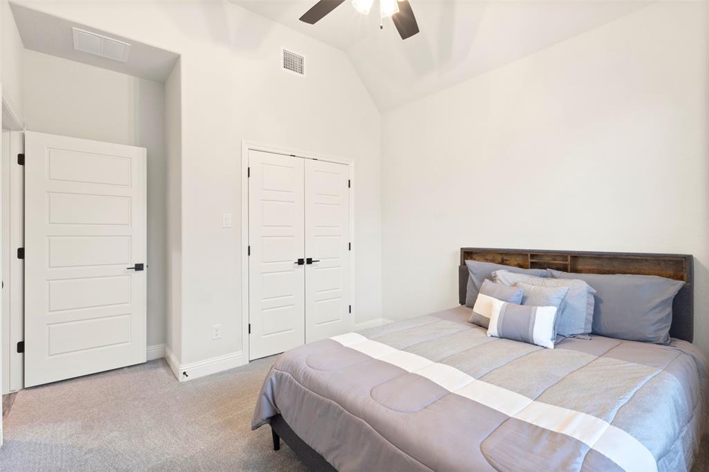 105 Clayton Crossing Springtown, TX 76082 - Photo 20 of 40 a bedroom with a bed and a chandelier