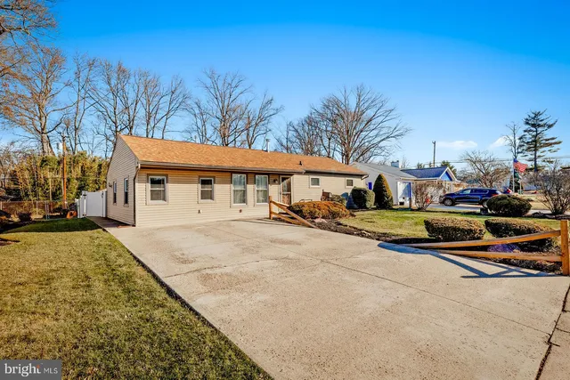 a view of a white house with a big yard and large trees