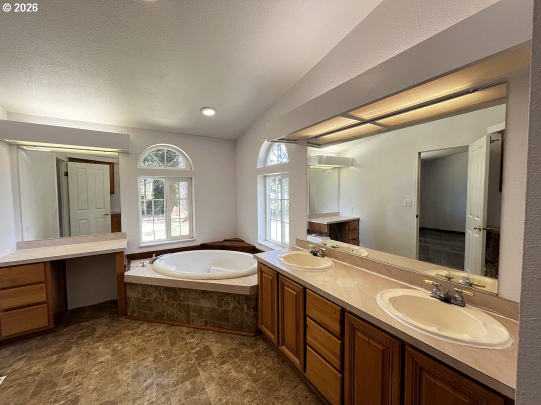 83411 Clear Lake Road Florence, OR 97439 - Photo 32 of 47 a bathroom with a double vanity sink a mirror and bathtub