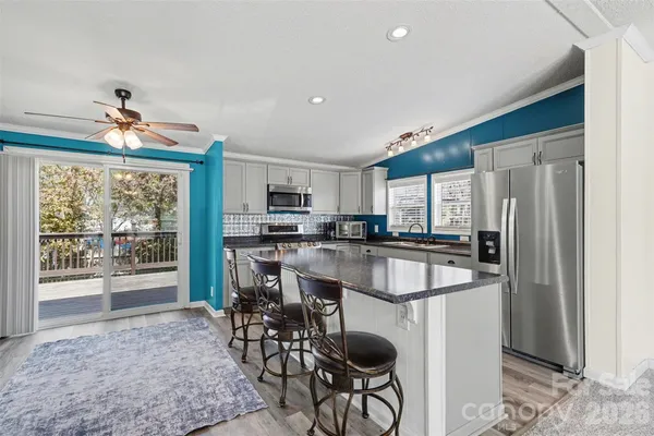 a kitchen with stainless steel appliances granite countertop a sink stove and refrigerator