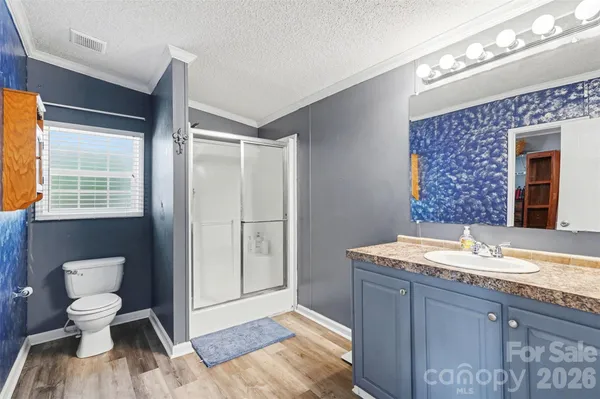 a bathroom with a granite countertop sink mirror vanity and a toilet