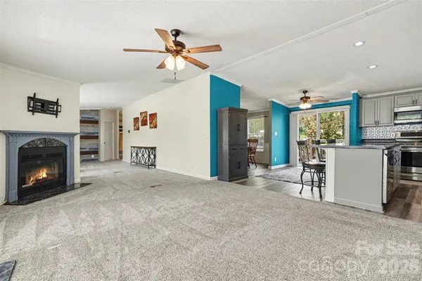 a kitchen with stainless steel appliances granite countertop a stove a refrigerator a sink a dining table and chairs with wooden floor