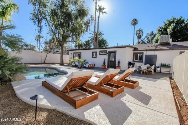 a view of backyard of house with seating area