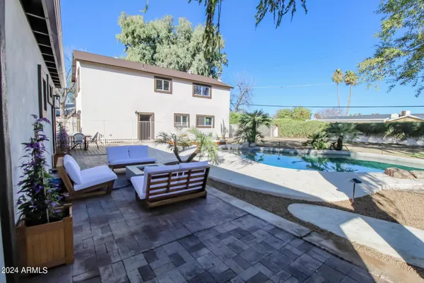 a swimming pool with outdoor seating and a potted plant