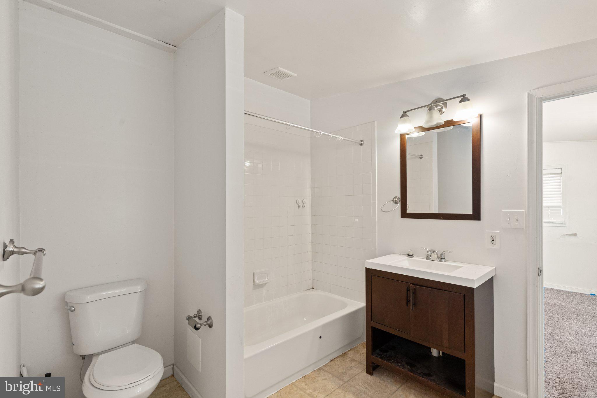 1047 Bowleys Quarters Road Middle River, MD 21220 - Photo 19 of 38 a bathroom with a toilet a sink a tub and mirror