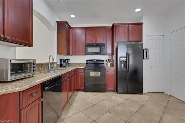 a kitchen with stainless steel appliances granite countertop a refrigerator stove top oven and sink