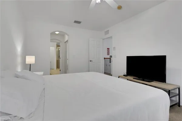 a bedroom with a bed and a flat tv screen on wall
