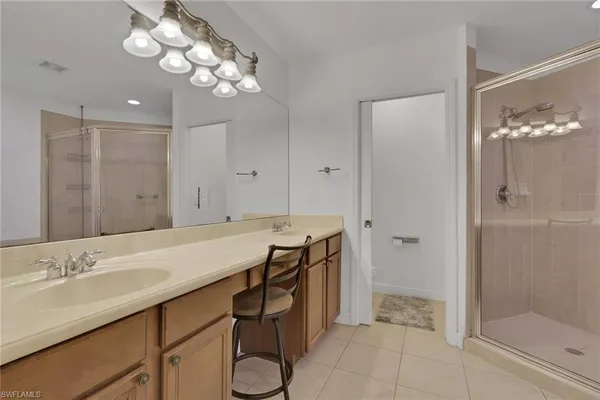 a spacious bathroom with a granite countertop sink a toilet a mirror and shower