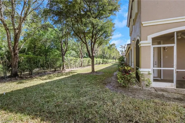 a view of a house with backyard and trees