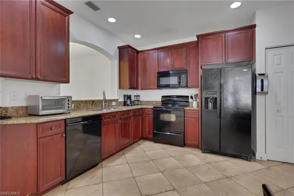 a kitchen with stainless steel appliances granite countertop a refrigerator stove and sink