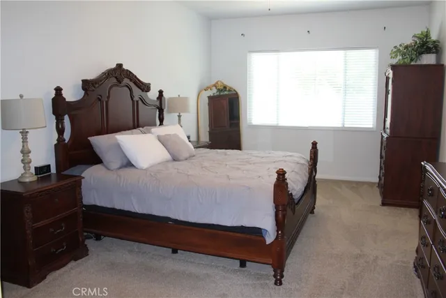 a bedroom with a bed and a flat tv screen on the dresser