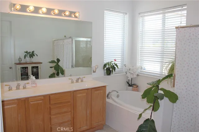 a bathroom with a granite countertop sink a large mirror a and a window