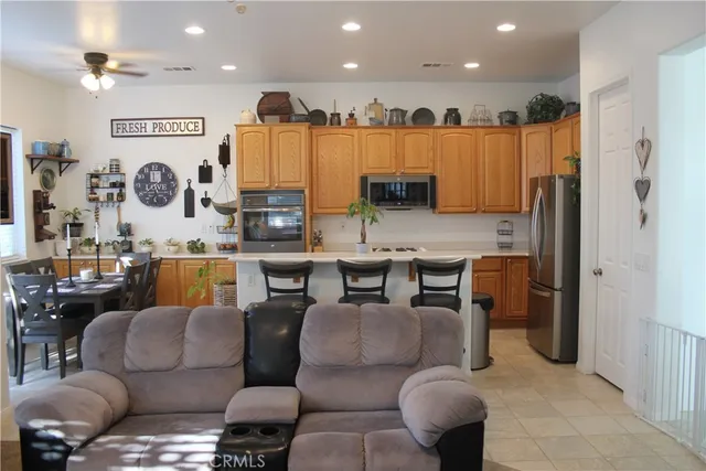 a living room with furniture kitchen view and a large mirror