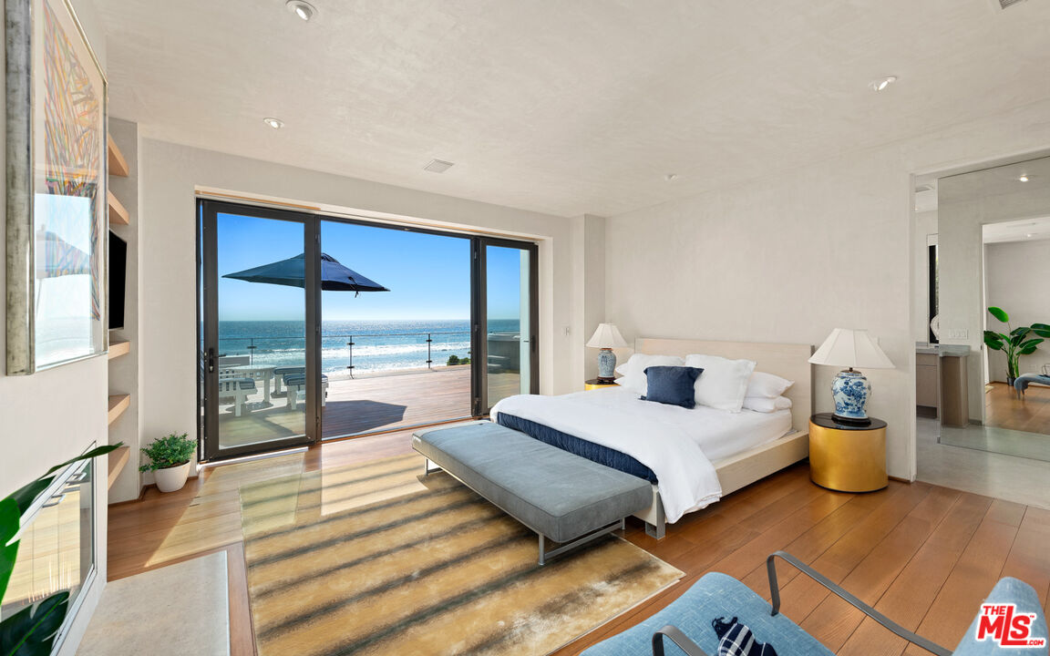 31240 Broad Beach Road Malibu, CA 90265 - Photo 24 of 54 a bedroom with a bed and large wooden floor