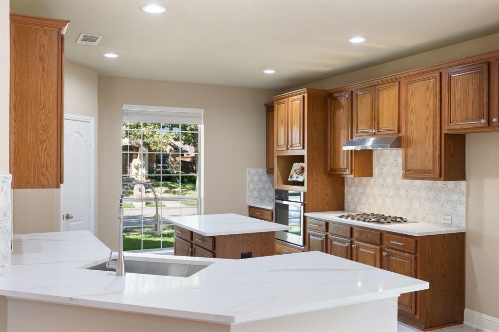 2475 Brazos Drive Frisco, TX 75033 - Photo 10 of 34 a room with stainless steel appliances kitchen island granite countertop a stove a sink and a microwave