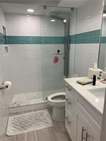 a bathroom with a sink a toilet and shower