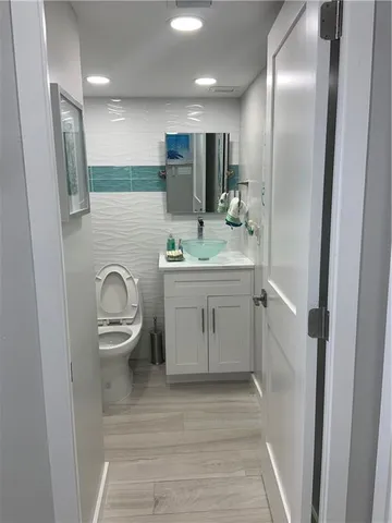 a bathroom with a sink a toilet and mirror