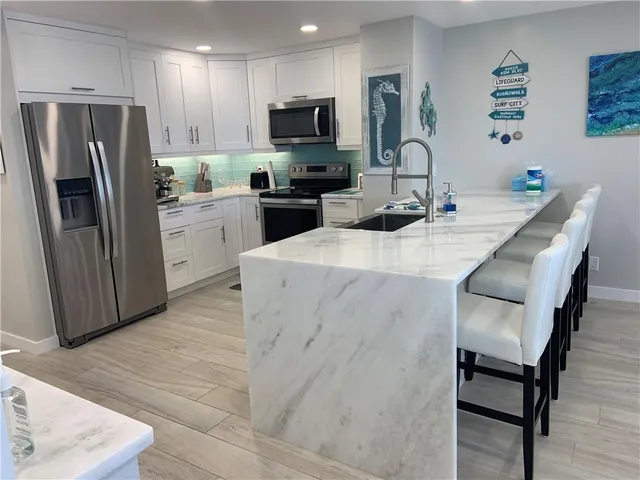 a kitchen with stainless steel appliances a microwave a sink a stove and refrigerator