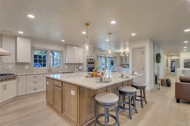 a room with stainless steel appliances kitchen island granite countertop a sink and cabinets