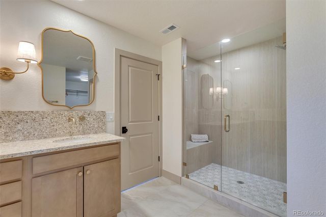a bathroom with a granite countertop sink a mirror and a bathtub
