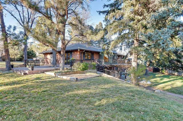 a view of a big yard with table and chairs under an umbrella