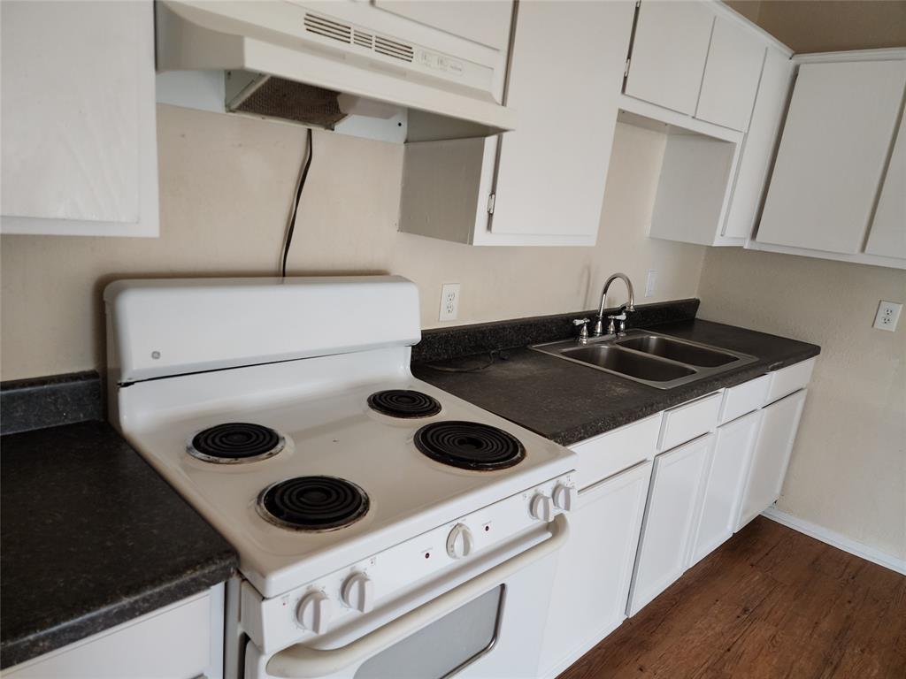 4304 South Cravens Road Fort Worth, TX 76119 - Photo 11 of 21 Kitchen with white cabinetry, sink, electric range, and dark wood-type flooring